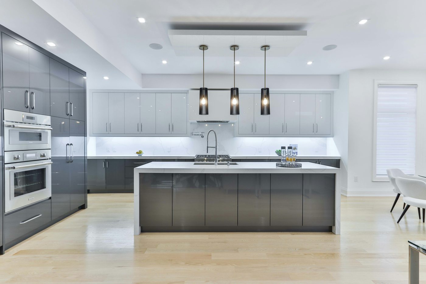 Glossy gray kitchen cabinetry with pendant lighting