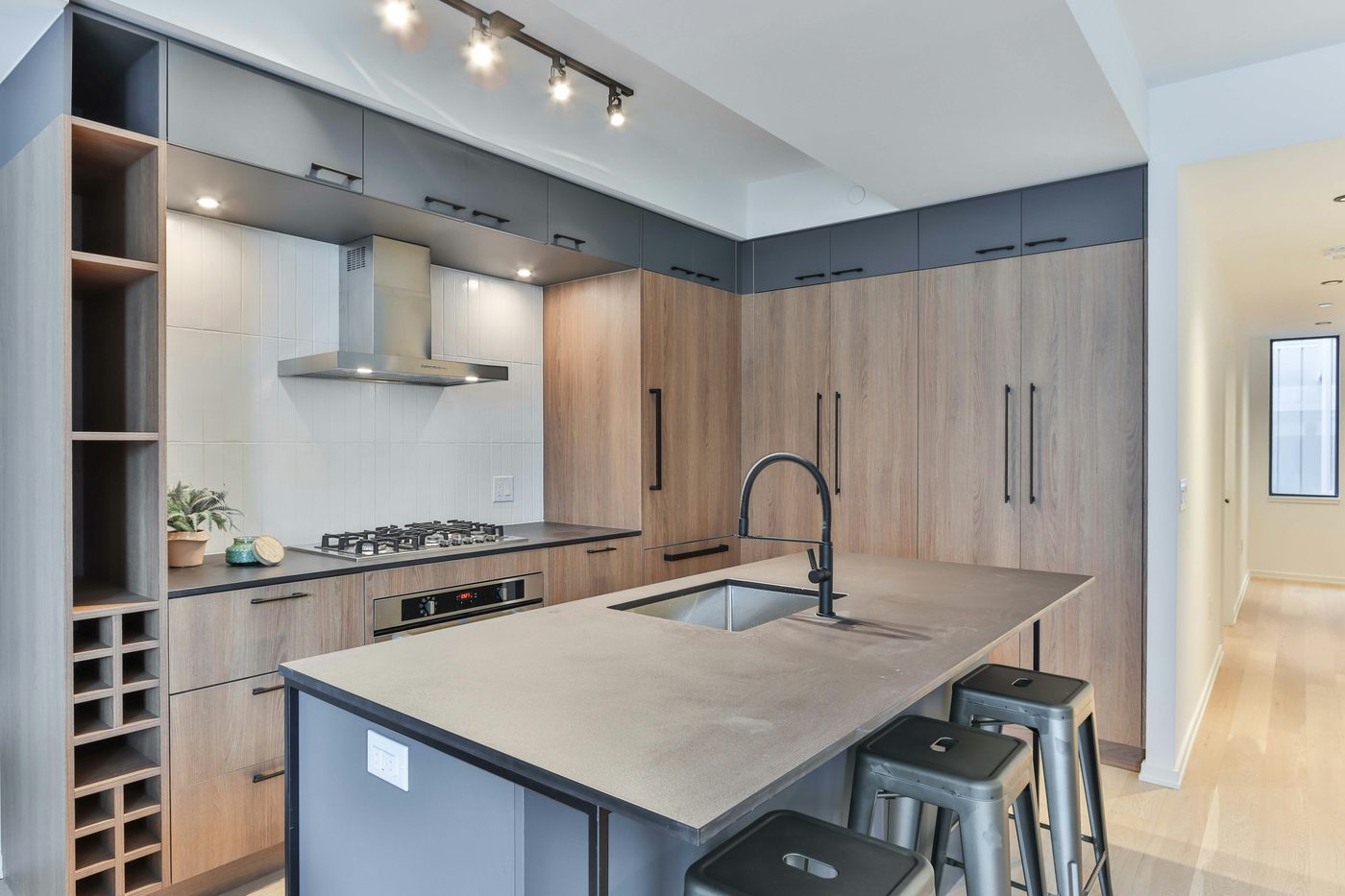 Wood-toned kitchen with waterfall island and wine storage
